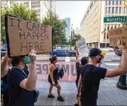  ?? JENNI GIRTMAN FOR THE AJC ?? Marchers pass the Atlanta Police Department during a Black Lives Matter protest Sept. 5. Some protesters called for redirectin­g funds from police department­s to mental health agencies and others.