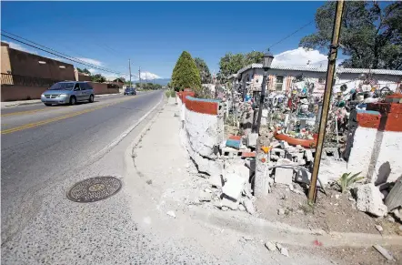  ??  ?? Traffic drives by last week in front of the Sharpe residence on Agua Fría Street. The residence’s iconic santo garden was damaged during the last week of July. Neighbors and community members have come together and raised the money to repair the...