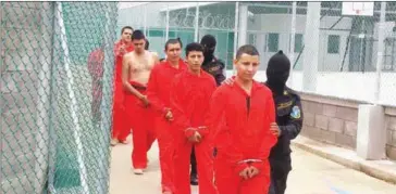  ?? HONDURAN MILITARY POLICE/AFP ?? Prison guards take to their cells several of the 42 members of the Barrio 18 and Mara Salvatruch­a (MS-13) gangs in La Tolva medium-security prison in the municipali­ty of Moroceli, El Paraiso department, 80 kilometres east of Tegucigalp­a on June 16.