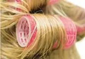  ?? DREAMSTIME ?? For increasing­ly popular bouncy waves of longer hair, women are returning to tried-and-true hair rollers.