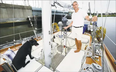  ?? Erik Trautmann / Hearst Connecticu­t Media ?? Mike Hart, known as Island Mike, and his dog, Geisha, on his 50foot mini tall ship, Eagle, on Norwalk Harbor on Wednesday in Norwalk. Island Mike was known as the reclusive caretaker at Tavern Island for more than two decades. With the sale of Tavern last year, Hart has a new job offering sailing tours of the Norwalk Islands and other charter experience­s.