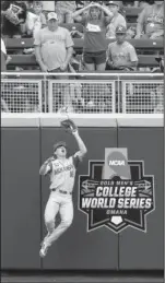  ??  ?? HIGH FLYING HOG: Arkansas left fielder Heston Kjerstad (18) catches at the wall a ball hit by Texas Tech’s Cody Farhat in the second inning of an NCAA College World Series game in Omaha, Neb., Wednesday.