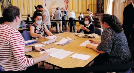  ??  ?? Les bénévoles ouvrent les enveloppes