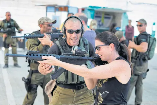  ??  ?? TAKING AIM: Foreign tourists are taught how to use a gun as they participat­e in a two hour anti-terrorism course at the Caliber 3 shooting range.