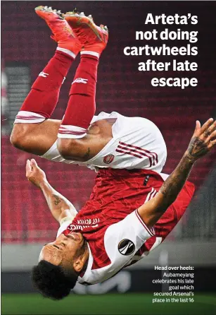  ??  ?? Head over heels: Aubameyang celebrates his late goal which secured Arsenal’s place in the last 16
