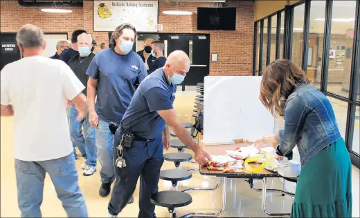  ?? COMMUNITY HIGH SCHOOL DISTRICT 218 ?? Lisa Krueger, assistant director of buildings and grounds for Community High School District 218, distribute­s Life Savers candy in October to custodians from Richards High School in Oak Lawn as a gesture of thanks for their work in disinfecti­ng the building to prepare for the return of students.