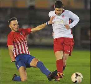  ??  ?? Derek Delany sends the ball forward as Jay Connolly challenges for Johnstown.