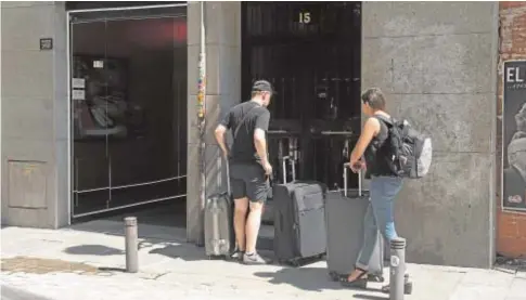  ?? // ABC ?? Un grupo de jóvenes frente a un edificio plagado de viviendas turísticas en Madrid