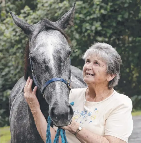  ??  ?? STRONG FORM: Cairns horse trainer Rhonda Inglis with her grey mare Lilly Kareena. Picture: ANNA ROGERS