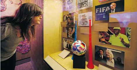  ?? JOHN LOCHER/THE ASSOCIATED PRESS ?? Krissi Reeves looks at the FIFA display at the Mob Museum in Las Vegas. The display is primarily made up of newspaper headlines and photos.