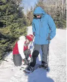  ?? FRAM DINSHAW/ TRURO NEWS ?? Heather Legere helps her son Nathan re-attach his right snowshoe after it came loose while they were out on the trails of Victoria Park on Jan. 19. They were part of a Special Olympics group practising their snowshoein­g.