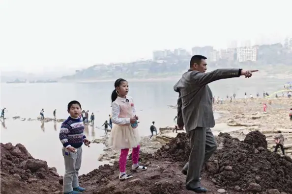  ??  ?? En middelklas­sefamilie er på vei til stranden Ciqikou en søndag i mars. Stranden ligger midt i byen Chongqing.