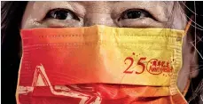  ?? ?? A woman wears a face mask with a slogan to celebrate the 25th anniversar­y of the city’s handover from Britain to China, in Hong Kong. (AFP)