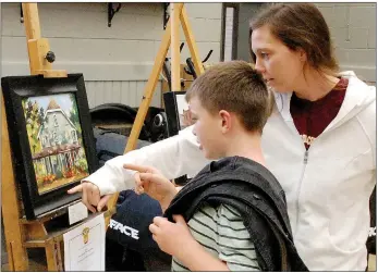  ?? (NWA Democrat-Gazette/Janelle Jessen) ?? Owen Tiegreen and his mother, Emily Tiegreen, view a painting during the Heart of America Artists Associatio­n Siloam Springs Plein Air Exhibit last weekend at Phat Tire Bike Shop.