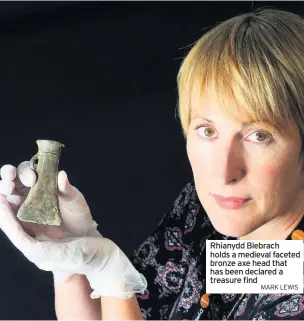  ?? MARK LEWIS ?? Rhianydd Biebrach holds a medieval faceted bronze axe head that has been declared a treasure find