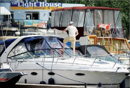  ?? CLIFFORD SKARSTEDT Examiner ?? Paul Whiteman cleans his cruiser on Friday at the Peterborou­gh Marina on Little Lake at Del Crary Park. Trent-Severn Waterway traffic was down in May and June because of several factors.