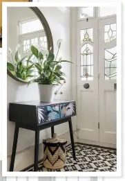  ??  ?? Original features, such as the hall’s practical, tiled  oor and pretty stained glass windows were a big draw for Sophie and Rich. The console table, which Sophie picked up on eBay, has been transforme­d with paint, découpage and new handles
