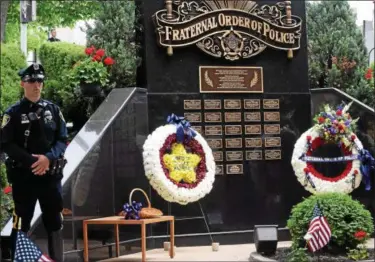 ?? MARIAN DENNIS – DIGITAL FIRST MEDIA ?? Wreaths and a basket of flowers adorned the Fraternal Order of Police Memorial that sits outside the Montgomery County Courthouse. A memorial service was held Friday to honor fallen Montgomery County officers.