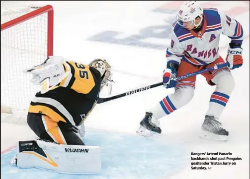  ?? AP ?? Rangers’ Artemi Panarin backhands shot past Penguins goaltender Tristan Jarry on Saturday.