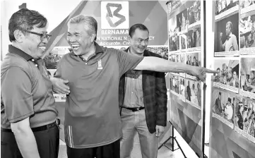  ??  ?? Ahmad Zahid sharing a light moment with Abang Johari as he gestures at a photo of himself with Uggah during his tour to exhibition booths held in conjunctio­n with ‘Ekspresi Negaraku’. - Bernama Photo