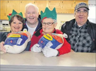  ?? ERIC MCCARTHY/JOURNAL PIONEER ?? Getting in the Christmas spirit as they prepare for the eighth annual Christmas Day meal are, Judy Peters, left; John and Jean Hagen, and Preston Murphy. Volunteers are welcome to join them at St. Anthony’s Hall in Woodstock on Christmas Eve as they...