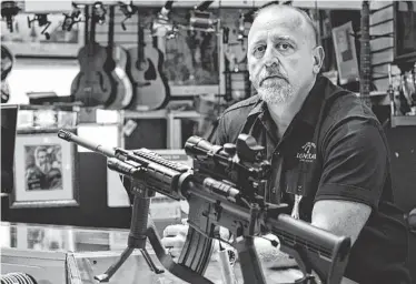  ?? DIRK SHADD/ TAMPA BAY TIMES ?? In the wake of the tragedy in Connecticu­t, pawn shop owner Frank James has decided to discontinu­e selling all firearms, including this Bushmaster AR15, at his shop Loanstar Jewelry and Pawn in Seminole, Fla. Sen. Dianne Feinstein of California plans to...