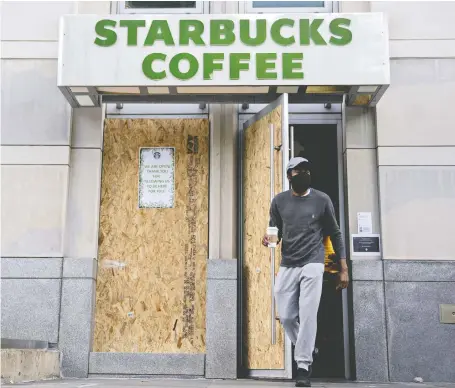  ?? ANDREW HARRER/BLOOMBERG ?? A customer exits a Starbucks in Washington, D.C., last week. Starbucks expects to report losses for its next earnings, including a fall in operating income by as much as US$2.2 billion. Its guidance underlines the depth of the challenges for consumer-facing businesses.