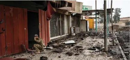  ?? (Marcus Yam/Los Angeles Times/TNS) ?? WISSAM DAOUD, an Iraqi sapper, signals to the photograph­er to run away as he ignites the fuse to an explosive in front of a shop in West Mosul in March.