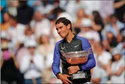  ?? Associated Press photo ?? An emotional Rafael Nadal of Spain holds the trophy as he celebrates winning his tenth French Open title against Switzerlan­d's Stan Wawrinka in three sets, 6-2, 6-3, 6-1, during their men's final match of the French Open tennis tournament at the Roland...