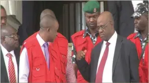  ??  ?? Okoyomon (second right) surrounded by EFCC operatives at the Federal High Court, Abuja… yesterday