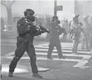  ?? MARCIO JOSE SANCHEZ/AP FILE ?? Federal officers deploy tear gas and crowd-control munitions during a Black Lives Matter protest in Portland, Ore., in July.