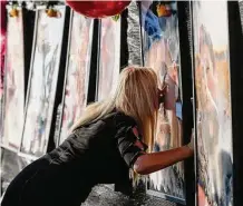  ?? Godofredo A. Vásquez / Staff file photo ?? Maria de los Angeles Peña kisses a photograph of her son, 23-year-old Rodolfo “Rudy” Peña, who was killed in the crowd surge at the Astroworld Festival in Houston, at a memorial for the victims outside NRG Park in November.