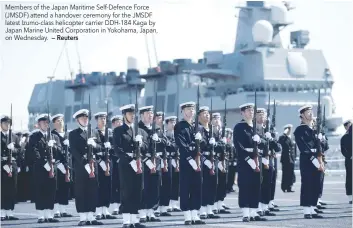  ?? — Reuters ?? Members of the Japan Maritime Self-Defence Force (JMSDF) attend a handover ceremony for the JMSDF latest Izumo-class helicopter carrier DDH-184 Kaga by Japan Marine United Corporatio­n in Yokohama, Japan, on Wednesday.