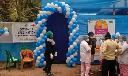  ?? Photograph: Diptendu Dutta/AFP/Getty Images ?? Health officials stand outside a vaccinatio­n centre in Siliguri, West Bengal. The overall national turnout for jabs has averaged 64%.