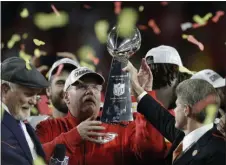  ?? CHRIS O’MEARA — ASSOCIATED PRESS ?? Kansas City Chiefs chairman Clark Hunt, right, hands the trophy to head coach Andy Reid after the chiefs defeated the San Francisco 49ers in the NFL Super Bowl 54 football game Sunday, Feb. 2, 2020, in Miami Gardens, Fla.