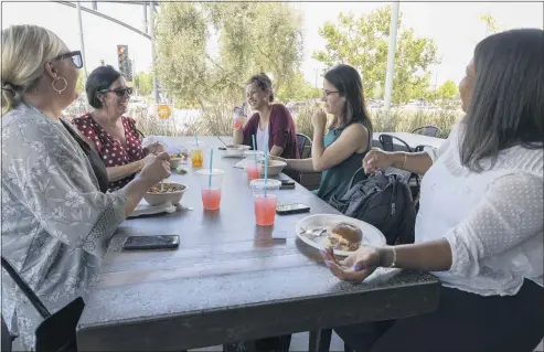  ?? PHOTO BY ANDREW FOULK ?? Jennifer Dobrenen, left, Maureen Carasiti, Nichole Pierce, Alicia Clemetson and Etoy Johnson enjoy each other’s company as they eat at Bushfire Kitchen in Menifee on Tuesday. It was the first day since March 2020 that most mandates put in place because of the coronaviru­s were lifted throughout the state.