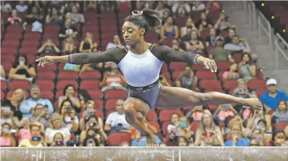  ?? TIMOTHY D. EASLEY ASSOCIATED PRESS ?? Simone Biles begins her balance beam routine Saturday at the U.S. Classic in Louisville, Ky. The four-time Olympic gold medalist and reigning world champion had an allaround score of 60.000, 2.100 points ahead of runner-up Riley McCusker.