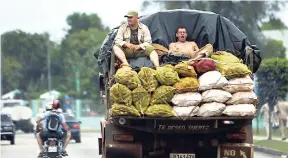  ?? AP ?? Workers ride on the back of a truck loaded with vegetables to sell at the market in Havana, Cuba, Tuesday, April 21, 2015.