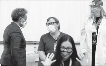  ?? JOSE M. OSORIO/CHICAGO TRIBUNE PHOTOS ?? Mayor Lori Lightfoot chats with nurse Mark Hooks at Loretto Hospital on Tuesday.