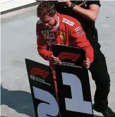  ?? FOTO: DPA ?? Sebastian Vettel vertauscht die Nummerntaf­el für den ersten und zweiten Platz.