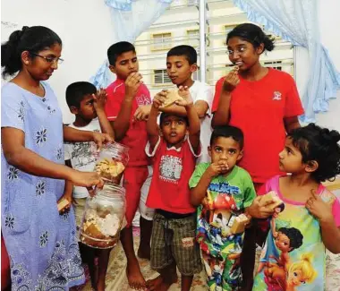  ??  ?? Better days ahead: Anne handing out some cookies to her children (back row, from left) K. Arun Kevin Raj, eight, Arvind Kevin Raj, 11, Arjun Kevin Raj, 12, Victoria Vimelia, 15, and (front row, from right) Vanesha Vimelia, five, Aron Kevin Raj, three,...