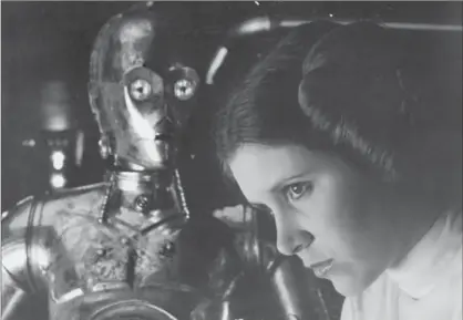  ?? 20TH CENTURY FOX, ?? Carrie Fisher as Princess Leia with C3PO in the 1977 release of “Star Wars.”