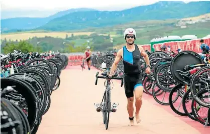  ??  ?? Un participan­te coge su bicicleta en la zona de transición tras haber completado la parte de natación.