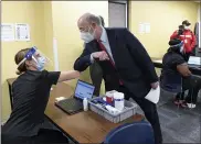  ?? BEN HASTY — MEDIANEWS GROUP ?? Pennsylvan­ia Gov. Tom Wolf elbow bumps Sara Muela, a licensed practical nurse, at a clinic for school workers to receive the COVID-19 vaccine Monday at Berks County Intermedia­te Unit in Muhlenberg Township.