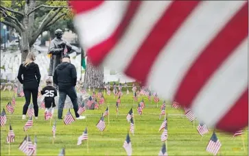  ?? Myung J. Chun Los Angeles Times ?? FLAGS at Los Angeles National Cemetery on Saturday honor Memorial Day. Southern California officials are preparing for huge crowds at beaches over the holiday weekend that marks the unofficial start of summer.