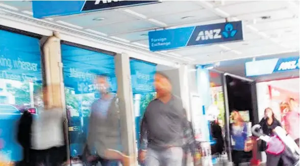  ?? Photo / Doug Sherring ?? Pedestrian­s pass a branch of ANZ on Auckland’s Queen St. The main banks have tightened their lending criteria following changes to the CCCFA.