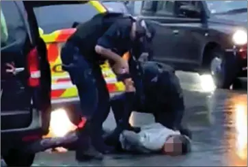  ?? ?? STRUGGLING: Armed police pin the suspect to the ground after stopping the taxi he was in