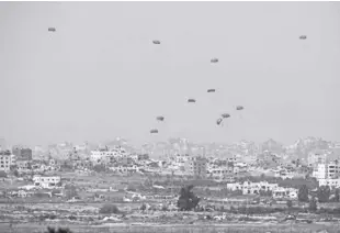  ?? AP/OHAD ZWIGENBERG ?? PARACHUTES drop supplies into the northern Gaza Strip, seen from southern Israel on Monday, April 15, 2024.