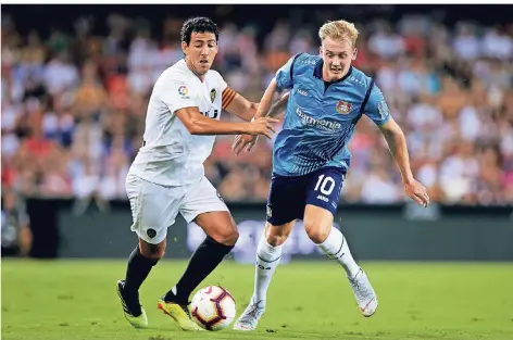  ?? FOTO: IMAGO ?? Leverkusen­s Nationalsp­ieler Julian Brandt im Zweikampf mit Valencias Dani Parejo (l.).