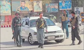  ?? REUTERS ?? Afghan policemen keep watch in downtown Kunduz, Afghanista­n, where the Taliban have launched an attack from all sides.